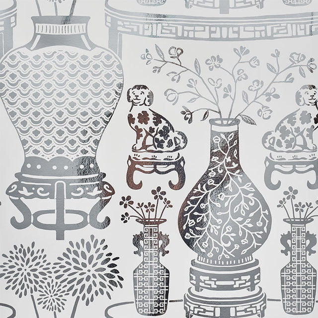 HELLENE MYLAR wallpaper features a preppy chinoiserie design with Ming vases and Staffordshire dogs in a mirrored silver pattern by Schumacher.