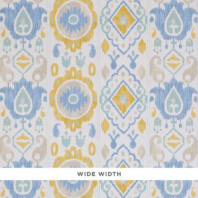 ELIZIA IKAT wallpaper in sky and ochre, a wide-width wallcovering with a delicate ikat pattern in blue, yellow, and beige tones.