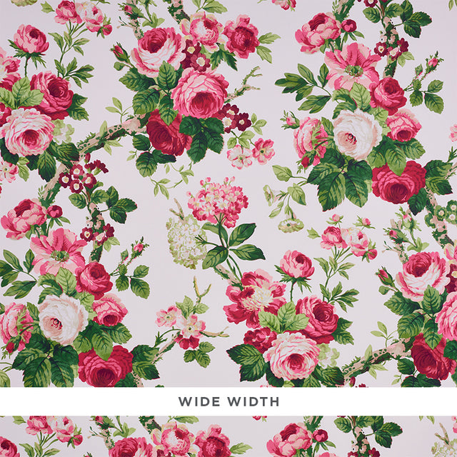 Nancy Floral wallpaper in Rose by Schumacher, featuring exuberant pink and red rose blossoms with green foliage on a light background.