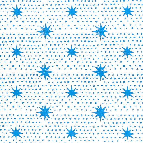 Blue dot and star block-print wallpaper by Molly Mahon for Schumacher, shown in a bedroom setting.