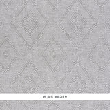 Tortola Paperweave wallpaper in grey with a diamond woven pattern, shown in detail and installed in a modern bedroom interior.