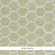 ABACO PAPERWEAVE green hexagonal woven wallcovering by Schumacher, shown in close-up and installed in a bedroom setting.