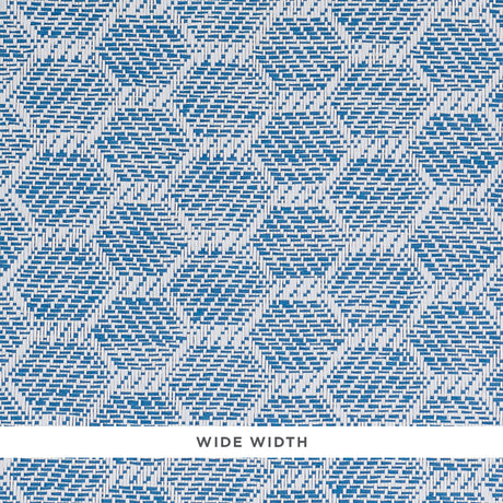 ABACO PAPERWEAVE blue hexagonal woven wallcovering by Schumacher shown in close-up and installed in a bedroom setting.