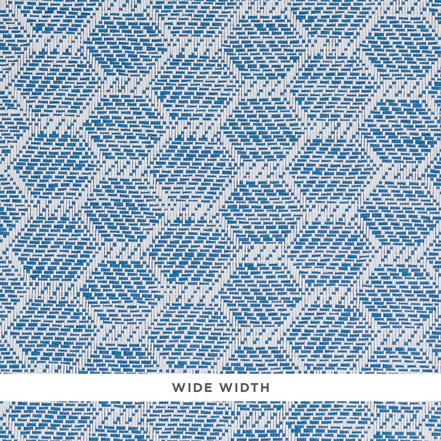 ABACO PAPERWEAVE blue hexagonal woven wallcovering by Schumacher shown in close-up and installed in a bedroom setting.
