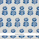 Rosenborg Navy stylized tulip Scandinavian modern wallpaper by Schumacher, shown in a bathroom interior and close-up pattern view.