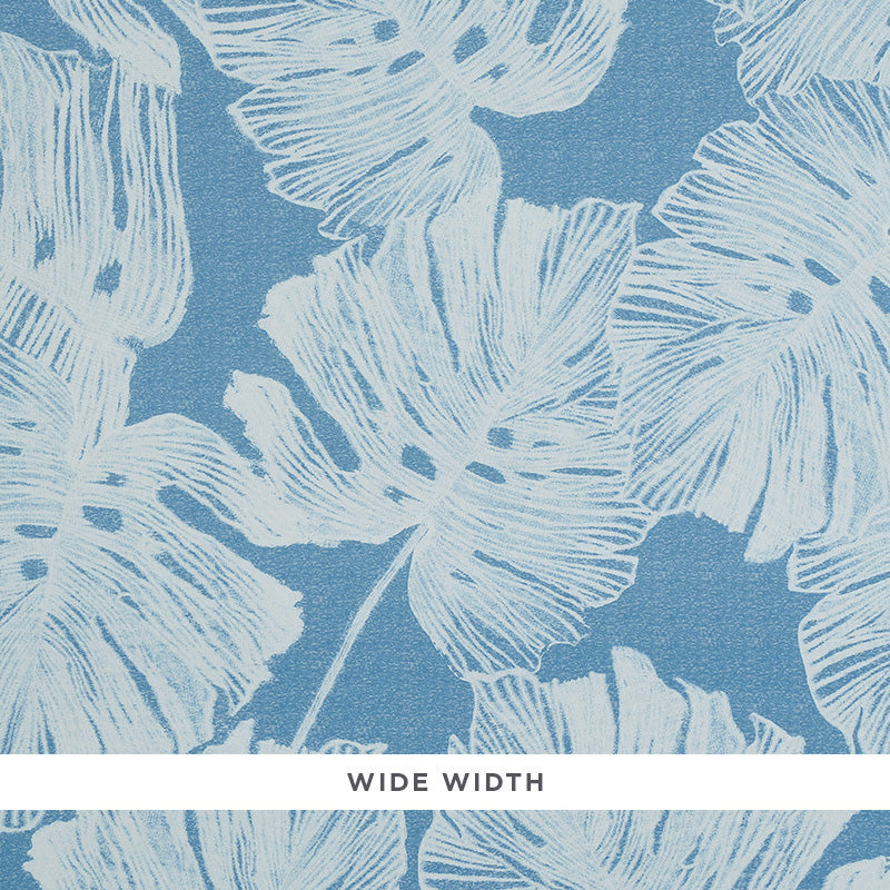 Del Coco Marine wallpaper by Schumacher featuring airy split leaf philodendron leaves in a soft watercolor effect on a blue background.