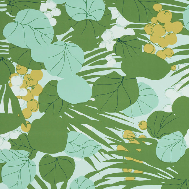 Painterly sea grapes and palm leaves in green and yellow on Schumacher SEA GRAPES wallpaper in Palm colorway, shown in a bright, sunlit room.