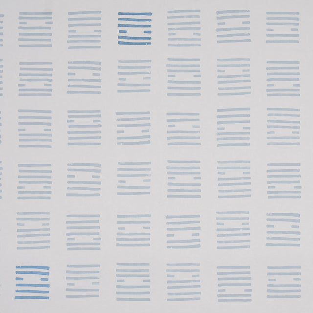 Tiasquam Sky by Caroline Z Hurley for Schumacher. Abstract hand-blocked look wallpaper in soft blue on white, shown in a modern living room setting.