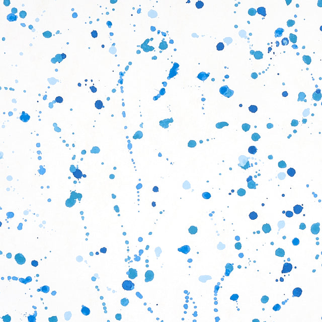 Blue ink splash abstract wallpaper by Schumacher, designed by Porter Teleo, shown in a modern interior setting.