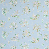 Magical Menagerie wallpaper in sky blue with whimsical birds, flowers, and fauna, styled in a bedroom setting by Schumacher.