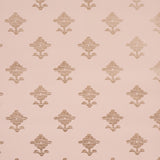 Rubia Blush wallpaper by Schumacher featuring stylized metallic floral motifs on a blush pink background, shown in a bathroom setting.