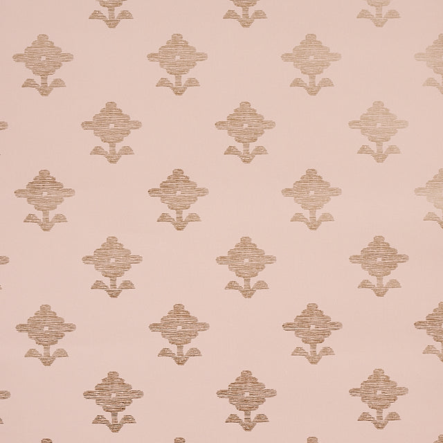 Rubia Blush wallpaper by Schumacher featuring stylized metallic floral motifs on a blush pink background, shown in a bathroom setting.