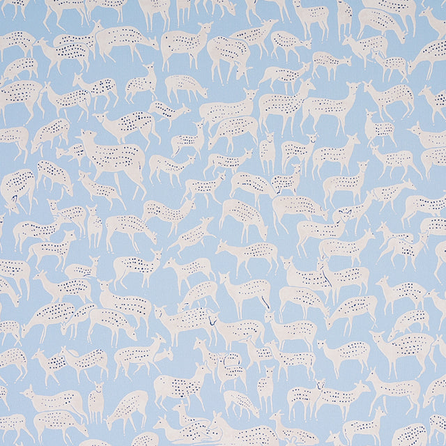 Slate blue wallpaper with hand-drawn white deer in a small-scale, whimsical pattern. Schumacher FAUNA 5012490.