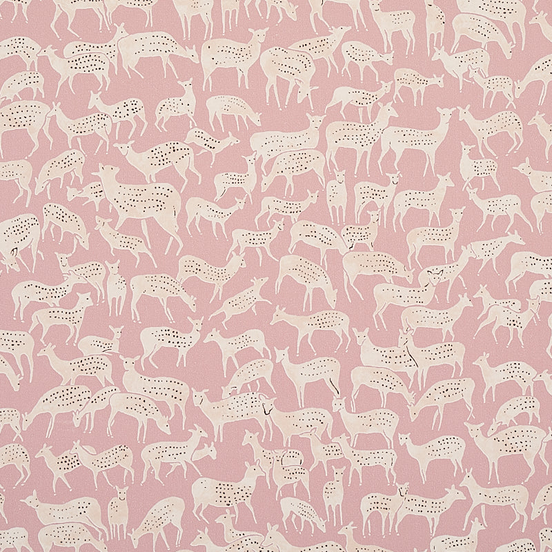Miniature herds of hand-drawn deer in white on a dusty pink background, Fauna wallpaper by Schumacher, styled in a modern bedroom.