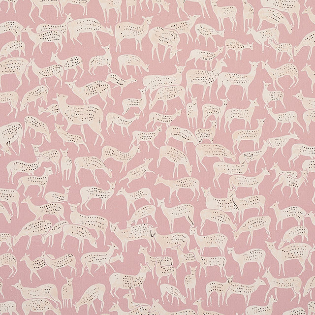 Miniature herds of hand-drawn deer in white on a dusty pink background, Fauna wallpaper by Schumacher, styled in a modern bedroom.