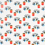 Reaching Out wallpaper by Peg Norriss for Schumacher, featuring playful spectrum multi-colored potted plants on a white background.