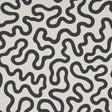 RILEY Soft Black abstract squiggle wallpaper by Schumacher, shown in a modern interior setting.