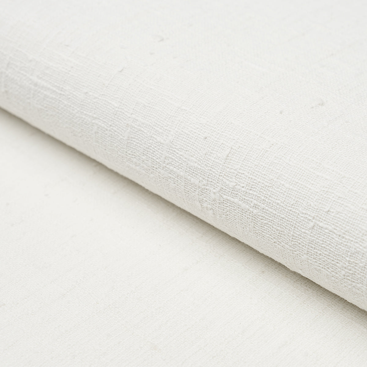 Linen Bark in white, a textured, handwoven linen wallcovering by Schumacher, shown in close-up and styled interior settings.
