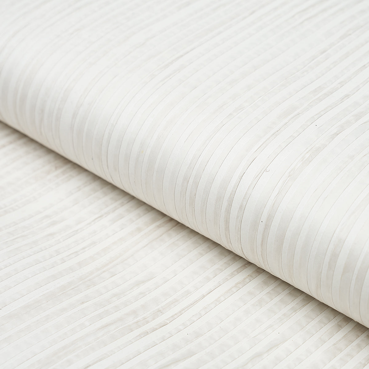 Paper Stripe in white wallcovering by Schumacher, featuring subtle matte and gloss vertical stripes with hand-applied paper strips.
