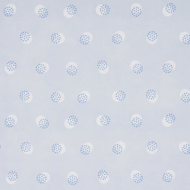 Taylor Blues wallpaper by Schumacher featuring offset-printed bursts of tiny blue dots over a field of larger dots, shown in a modern interior setting.