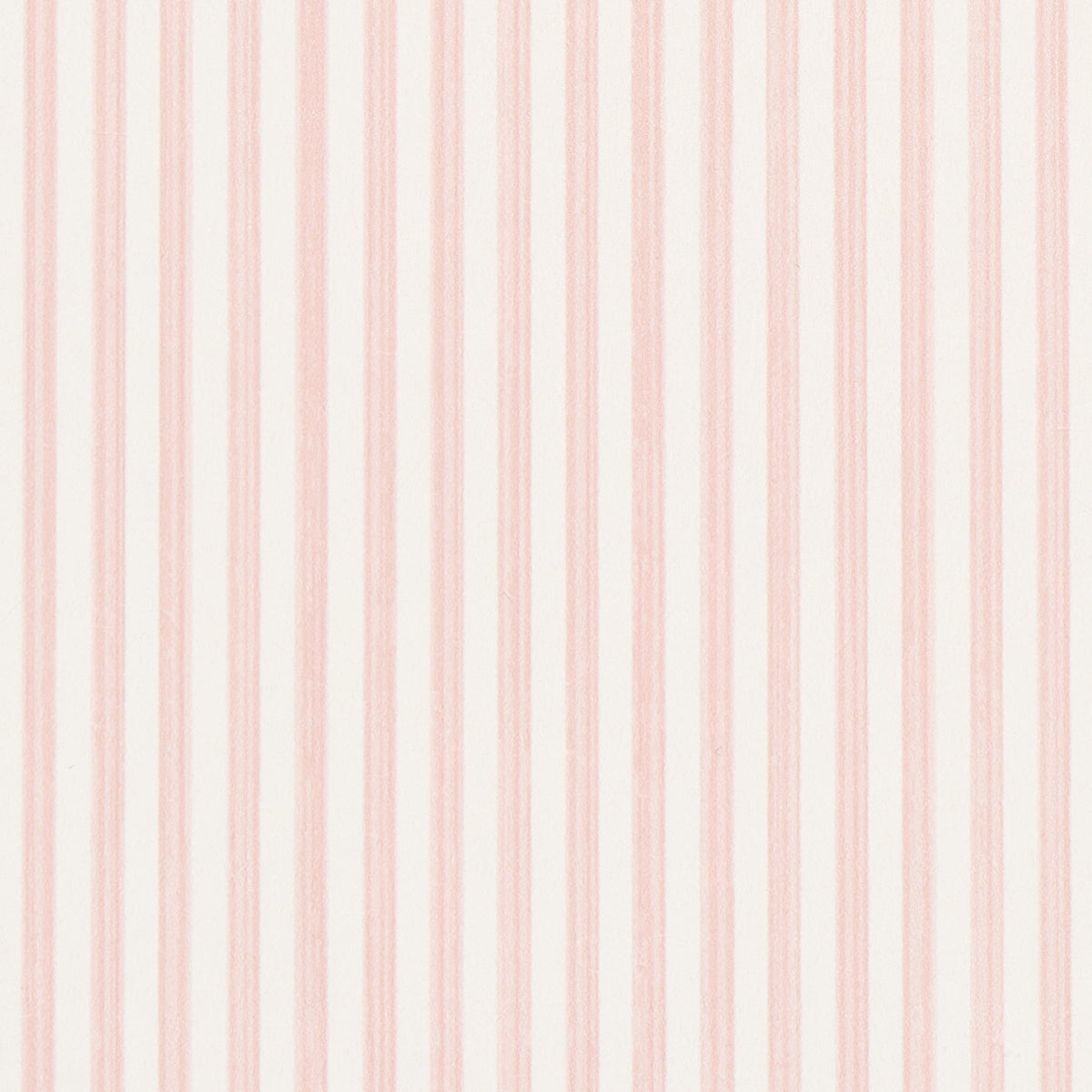 Edwin Stripe Narrow wallpaper in Petal by Schumacher, featuring narrow pink stripes on a white background, shown in a bright, classic interior setting.