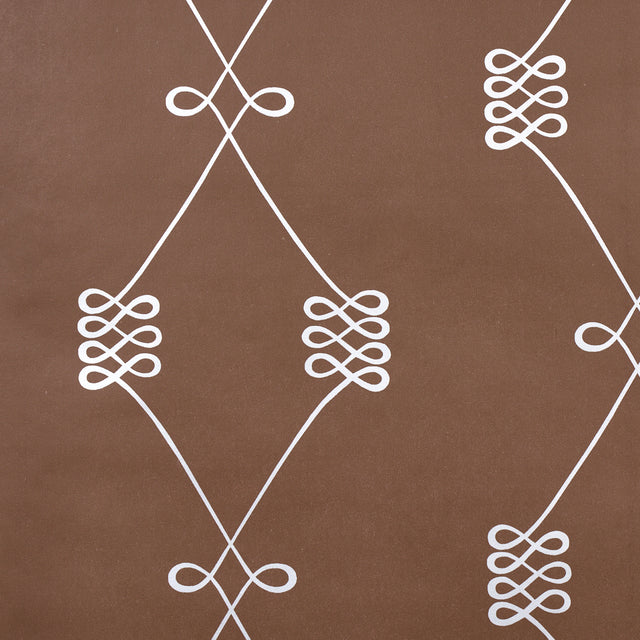 Nicolette wallpaper in silver on brown, featuring a swirling trellis motif by Schumacher.