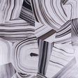 Black and white abstract agate slice patterned wallpaper by Schumacher, designed by Miles Redd, shown in a styled interior and close-up views.