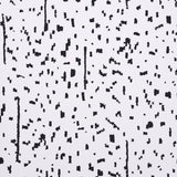 BESPOTTED wallpaper in black and white abstract spotted pattern by Schumacher, shown in a modern living room setting.