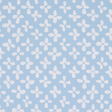 Emerson wallpaper in ivory on sky blue, small-scale quatrefoil-inspired print by Schumacher, shown as a roll and installed in a bright room.