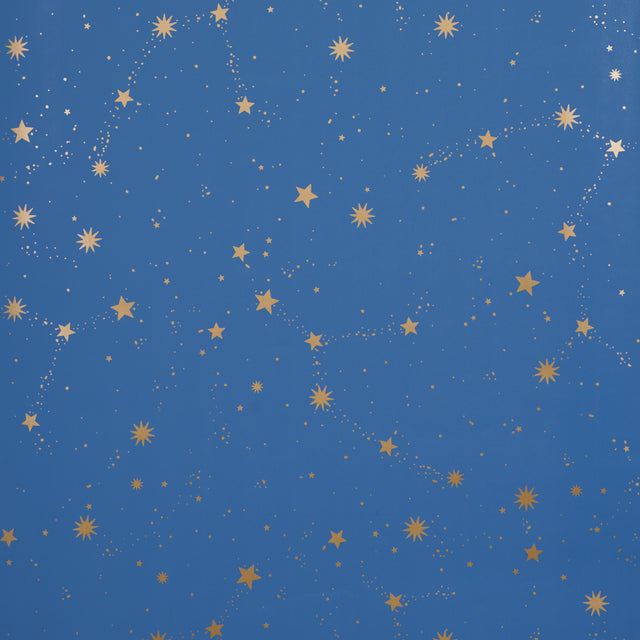 Scattered Stars wallpaper in Night by Marie-Chantal for Schumacher, featuring a constellation of metallic gold stars on a deep blue background.