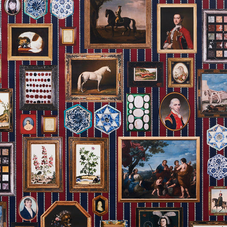 Le Grand Tour wallpaper by Johnson Hartig for Schumacher, featuring a trompe l'oeil gallery of antique paintings and collectibles on a striped background.