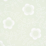 TUDOR ROSE wallpaper in Pistachio by Schumacher, featuring a large-scale floral pattern in white on a soft green background, styled in a bedroom setting.