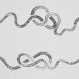 Rhapsody Graphite by Schumacher - Large-scale calligraphic stripe wallpaper in graphite on white, shown in a bedroom setting.
