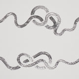 Rhapsody Graphite by Schumacher - Large-scale calligraphic stripe wallpaper in graphite on white, shown in a bedroom setting.