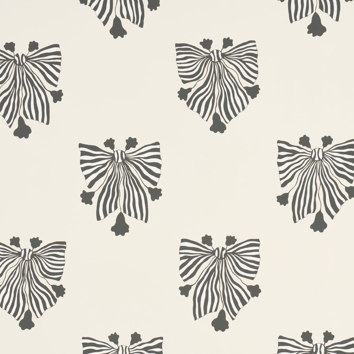 Bow-Wow-Wow wallpaper in cream by Schumacher, featuring whimsical black and white bow motifs on a cream background, styled in a modern interior.
