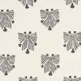 Bow-Wow-Wow wallpaper in cream by Schumacher, featuring whimsical black and white bow motifs on a cream background, styled in a modern interior.