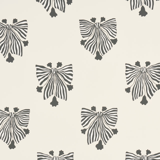 Bow-Wow-Wow wallpaper in cream by Schumacher, featuring whimsical black and white bow motifs on a cream background, styled in a modern interior.