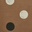 Monte Carlo wallpaper by Schumacher features a random polka-dot pattern in earthy brown with large-scale dots, inspired by stacked dice.