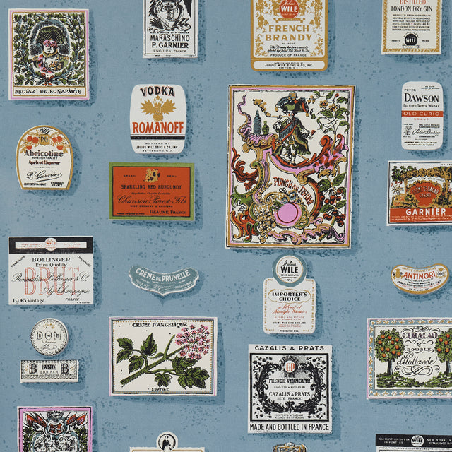 SALUD wallpaper in Curacao by Schumacher, featuring retro liquor bottle labels on a blue background.