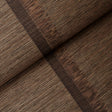 Axel Fringe Wallcovering in brown and copper, a large-scale vertical stripe wallpaper with fringe detail by Schumacher, shown in a styled bedroom.