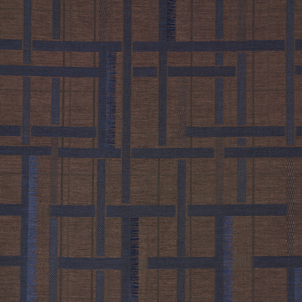 AXEL PLAID WALLCOVERING in Navy/Espresso by Schumacher. Artisanal geometric jacquard weave wallpaper with cut fringe detail, shown in a styled bedroom.