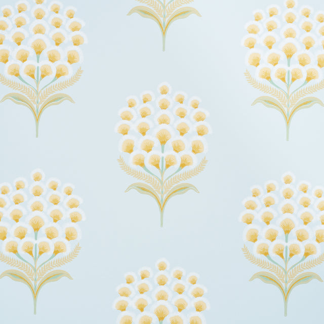 Aurelia Sky wallpaper by Schumacher featuring large stylized yellow and white blossoms on a soft blue background, shown in a bathroom setting.