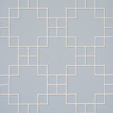 Georgette Trellis wallpaper in light blue with a geometric lattice pattern by Schumacher, shown in a styled bathroom interior.