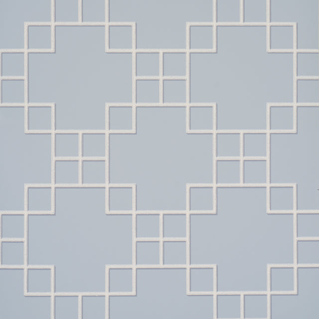 Georgette Trellis wallpaper in light blue with a geometric lattice pattern by Schumacher, shown in a styled bathroom interior.