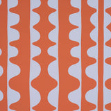 DRIFT wallpaper in Currant by Schumacher, featuring bold wavy vertical stripes in orange and white, modern geometric design.