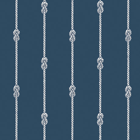 Navy blue wallpaper with vertical white nautical rope stripes and figure-eight knots, styled in a coastal interior setting.