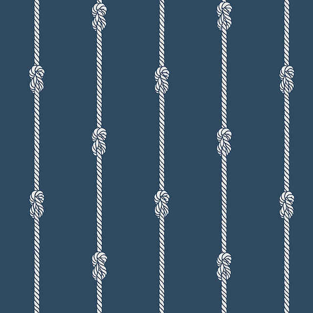 Navy blue wallpaper with vertical white nautical rope stripes and figure-eight knots, styled in a coastal interior setting.